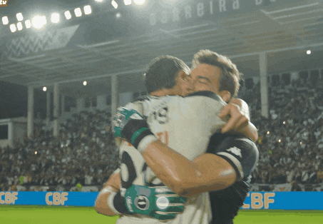 two soccer players hugging in front of a banner that says cbf on it