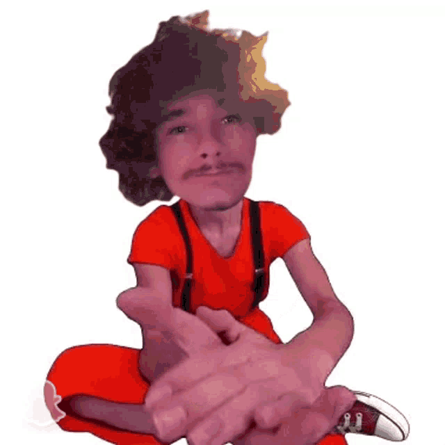 a man in a red shirt and suspenders sits on the floor