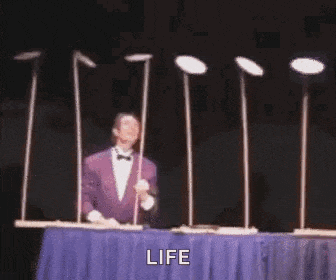 a man is standing in front of a table with plates on it and the word life written on it .