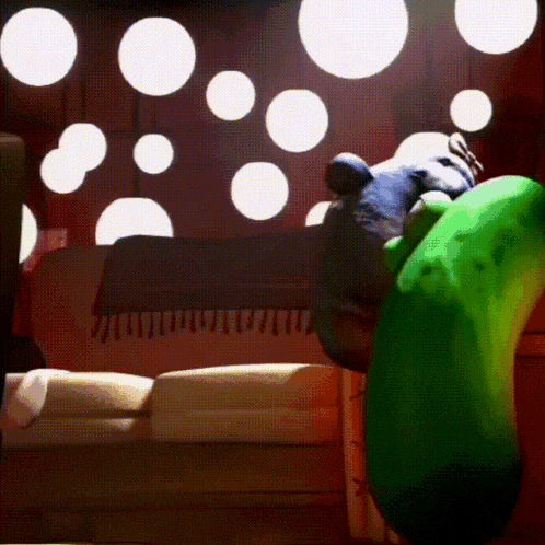 a green cartoon character is sitting on a couch in a room