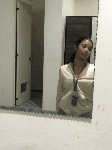 a woman taking a picture of herself in the mirror