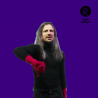 a man with long hair is giving a thumbs up in front of a sign that says teatr rozbark