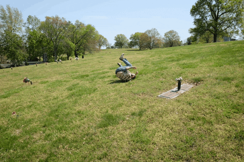 a man is doing a handstand in a cemetery