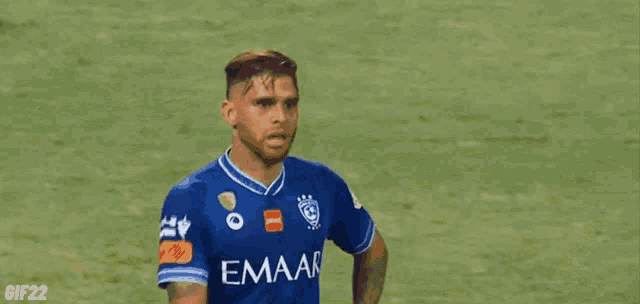 a soccer player wearing a blue emaar jersey