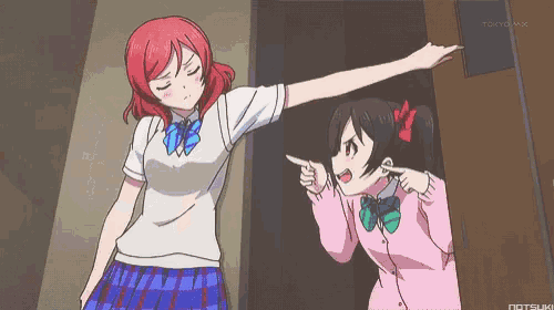a girl in a pink shirt is pointing at another girl in a white shirt