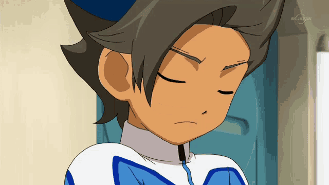 a close up of a boy 's face with a tv channel displayed in the background