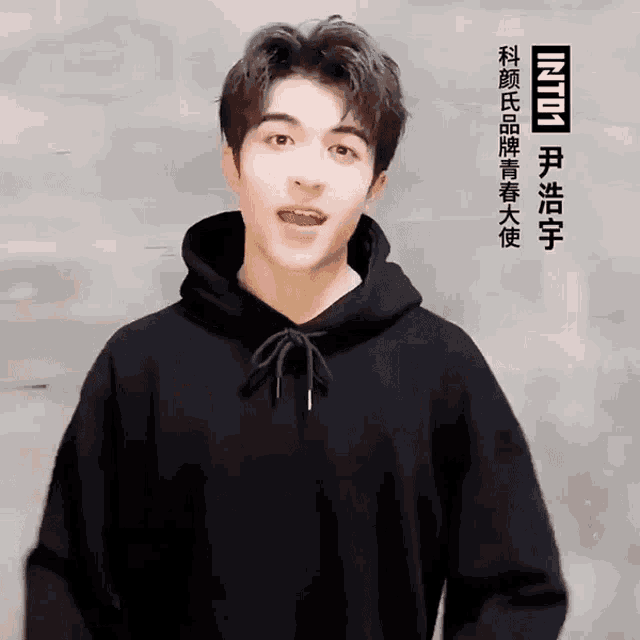 a young man wearing a black hoodie with the word into on the bottom right