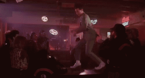 a man is dancing in front of a bud light sign .