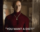 a bald man wearing a turtleneck sweater and a necklace is standing in a room and talking to another man .