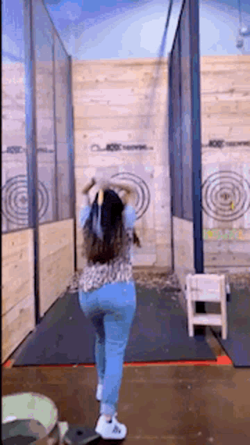 a woman is throwing an axe at a target