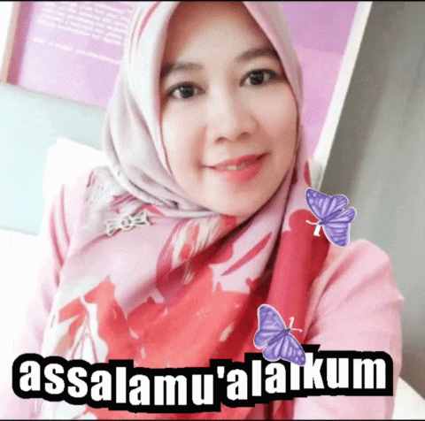 a woman wearing a hijab and a pink shirt with the words assalamu'alaikum