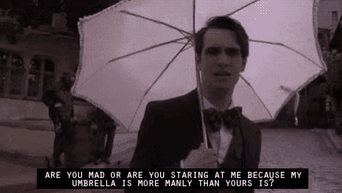 a man in a tuxedo is holding a white umbrella .