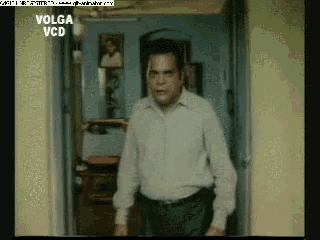 a man in a white shirt is standing in front of a sign that says volga vcd on it