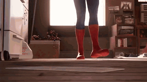 a person in a spiderman costume is standing in a room