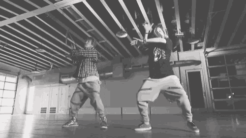 a black and white photo of two people dancing with one wearing a t-shirt that says nasa