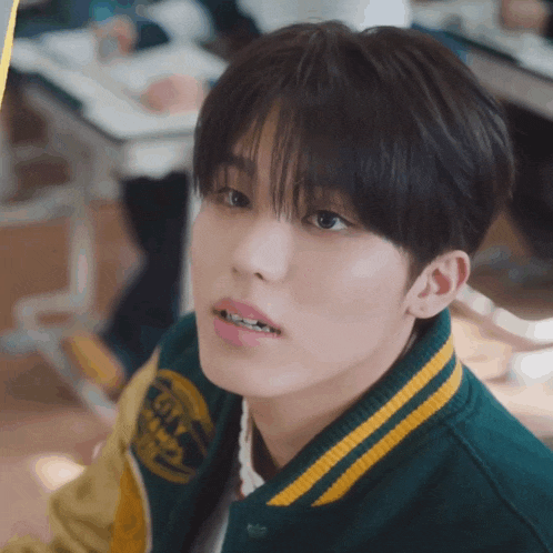 a close up of a boy wearing a green and yellow jacket