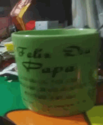 a green mug with the words feliz dia papa on it