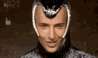 a close up of a man wearing a helmet and smiling