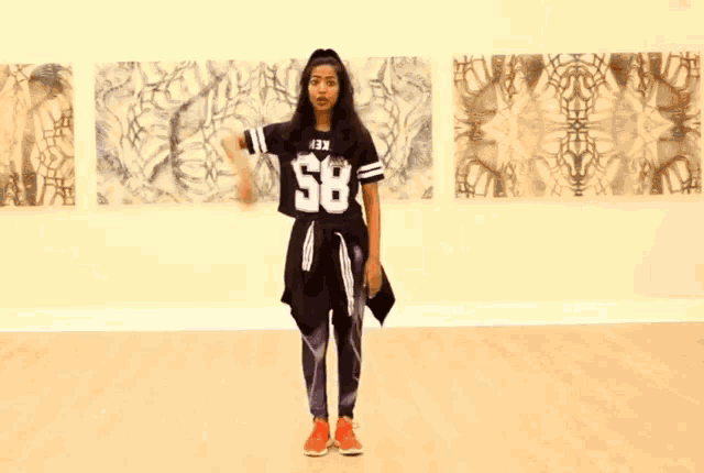 a girl wearing a number 58 jersey is dancing