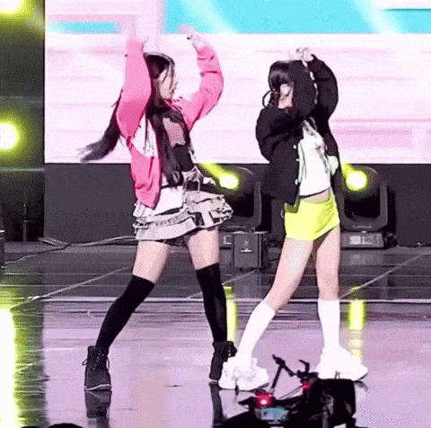 a couple of girls are dancing on a stage .