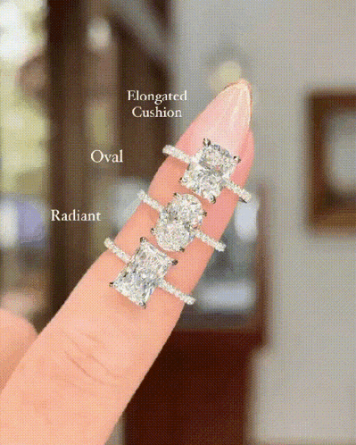 a woman 's finger with three different types of rings on it .