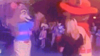 a blurry picture of a group of people standing in a crowd .