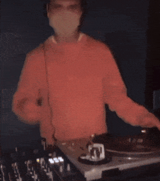 a man wearing a mask playing a record on a turntable