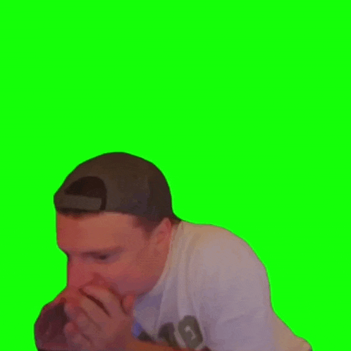 a man wearing a baseball cap is covering his mouth with his hands .