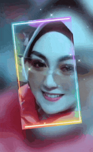 a woman wearing glasses and a hijab is smiling in a rainbow colored frame