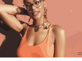 a woman wearing glasses and an orange tank top
