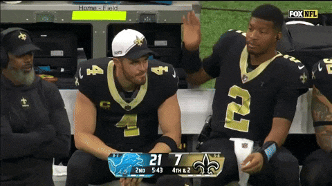 two new orleans saints players are sitting on the bench during a game