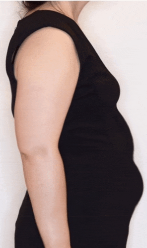 a woman in a black dress is standing with her arms crossed