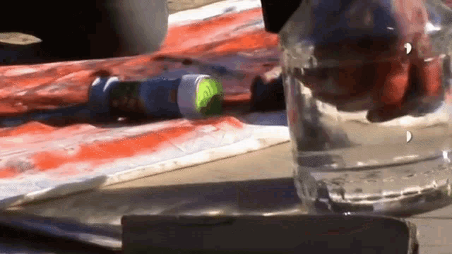 a bottle of water sits on a table next to a spray can that has the letter a on it