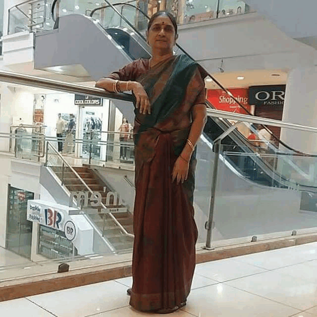 a woman stands in front of an escalator in a shopping mall with a sign that says shopping on it