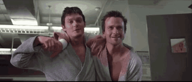 two men are standing next to each other in a room .