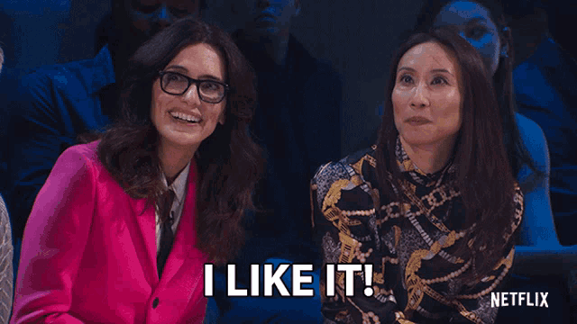 two women sitting next to each other with the words " i like it " on the screen