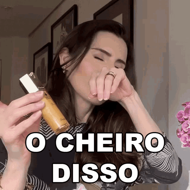 a woman with a ring on her finger is holding a bottle of perfume and says o cheiro disso