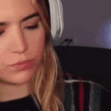 a close up of a woman wearing headphones while looking down .