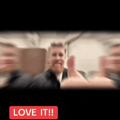 a blurry picture of a man giving a thumbs up with the words love it ! below him