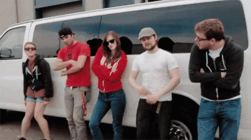 a group of people are standing in front of a white van with the letter m on it