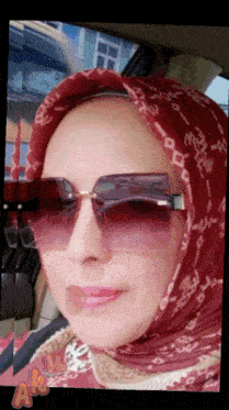 a woman wearing sunglasses and a scarf with the word ak on the bottom right