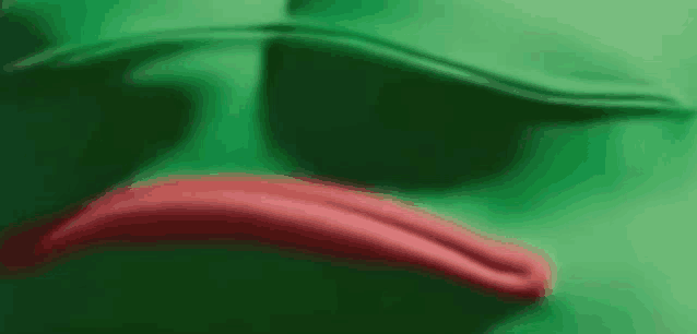 a close up of a green frog with a red mouth .