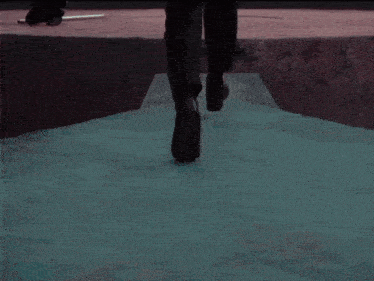 a man in a suit is kneeling down on a red surface