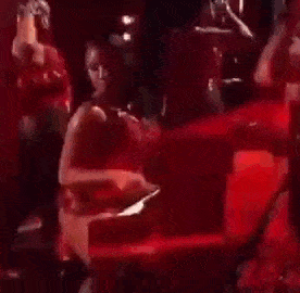 a woman in a red dress is sitting on a red chair .