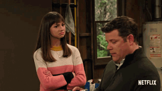 a man and a woman standing next to each other with netflix written on the bottom right