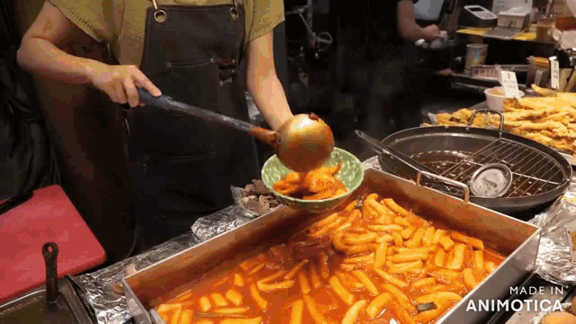 a person is pouring something into a bowl with a ladle that says made in animotica on the bottom