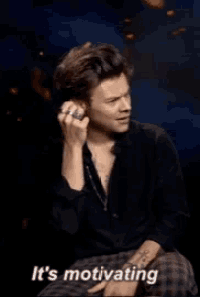 a man with a ring on his finger is sitting down and saying it 's motivating