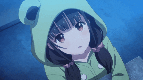 a girl in a green frog costume looks up at the camera