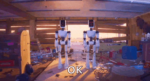 two robots are standing next to each other in a room with the word ok on the bottom right
