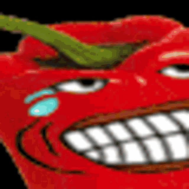 a close up of a red pepper with a big mouth and teeth .